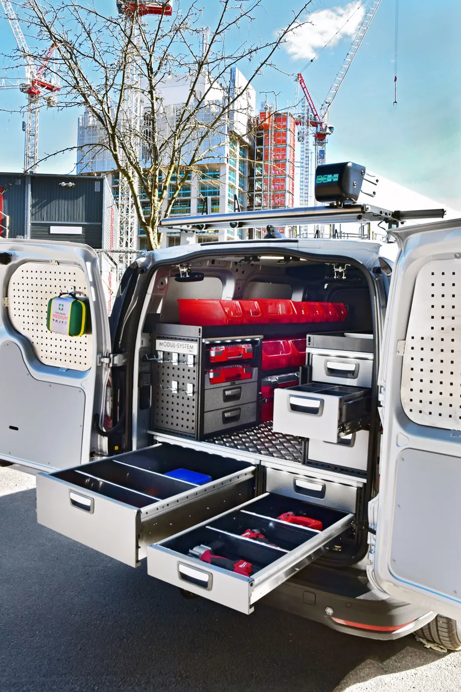 Open rear doors of a van showing pull-out drawer units and tool storage on a racking system