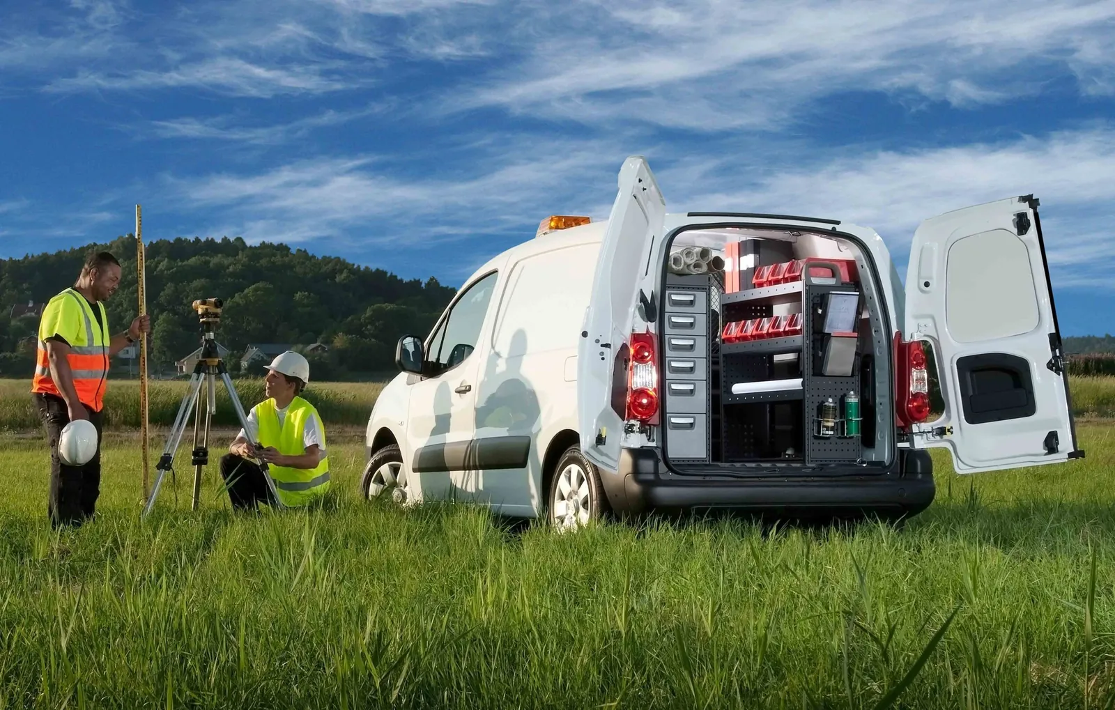 Two surveyors beside a van with racking visible through the open rear doors